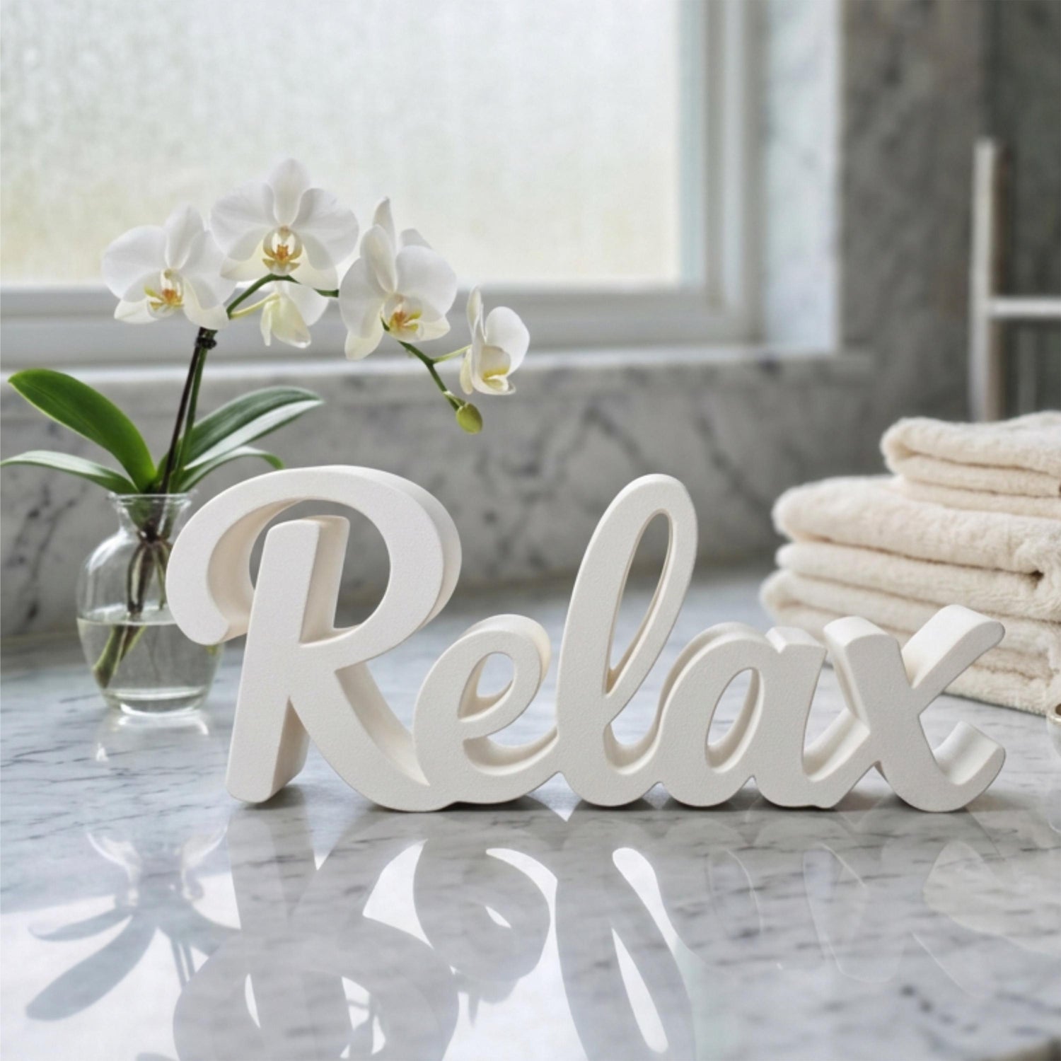 White Relax sign on marble surface with flowers and towels – spa bathroom decor, made in USA